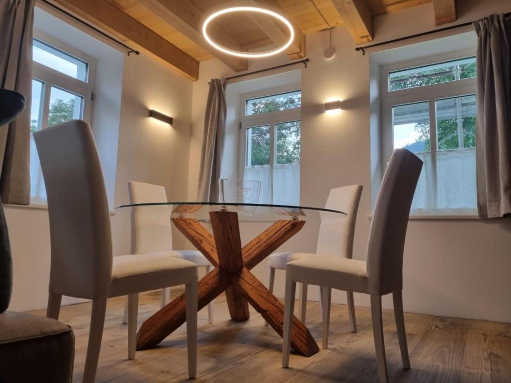 a dining room with a glass table and chairs at Appartamento Vale e Schena Cortina D'Ampezzo in San Vito di Cadore