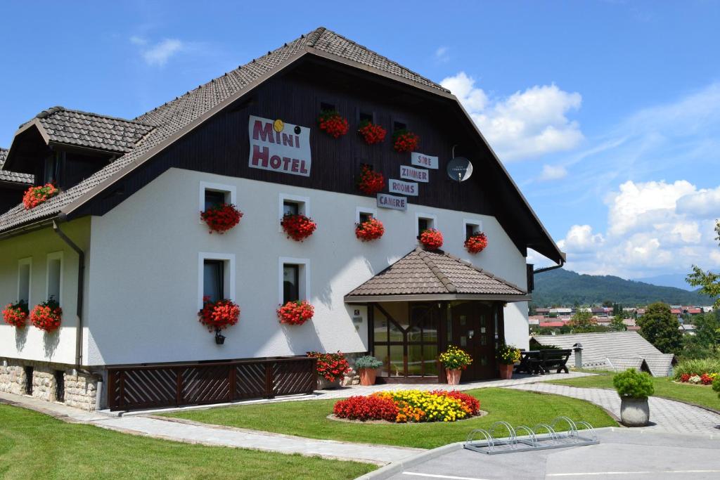 un edificio blanco con flores delante en Mini Hotel, en Škofja Loka