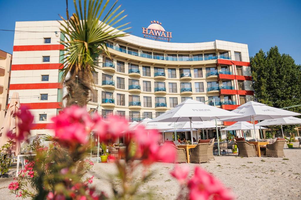 un hotel con tavoli e sedie di fronte a un edificio di Hotel Hawaii a Mamaia