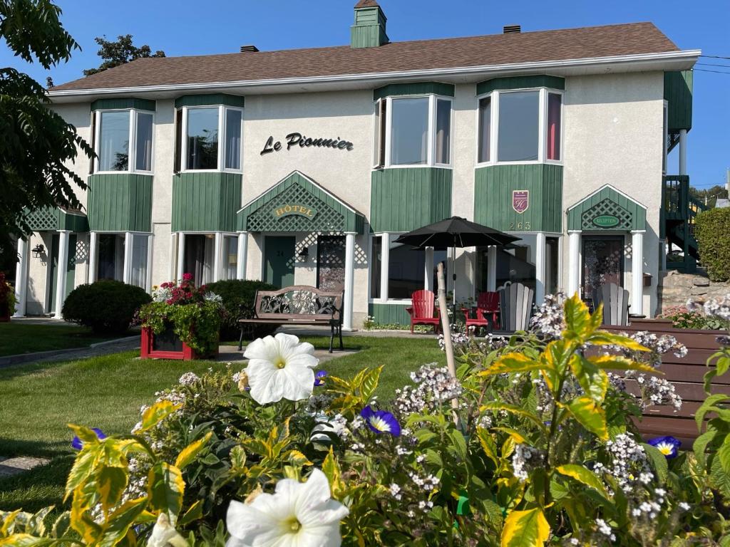 un edificio con dei fiori davanti di Hotel Le Pionnier a Tadoussac