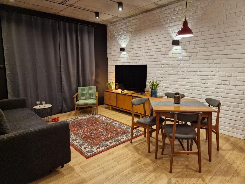 un soggiorno con tavolo e TV di Apartamenty LOFTykocin a Tykocin