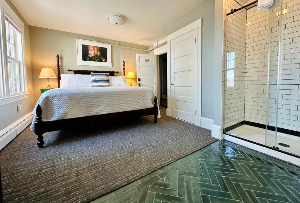 a bedroom with a bed and a walk in shower at Gifford House in Provincetown