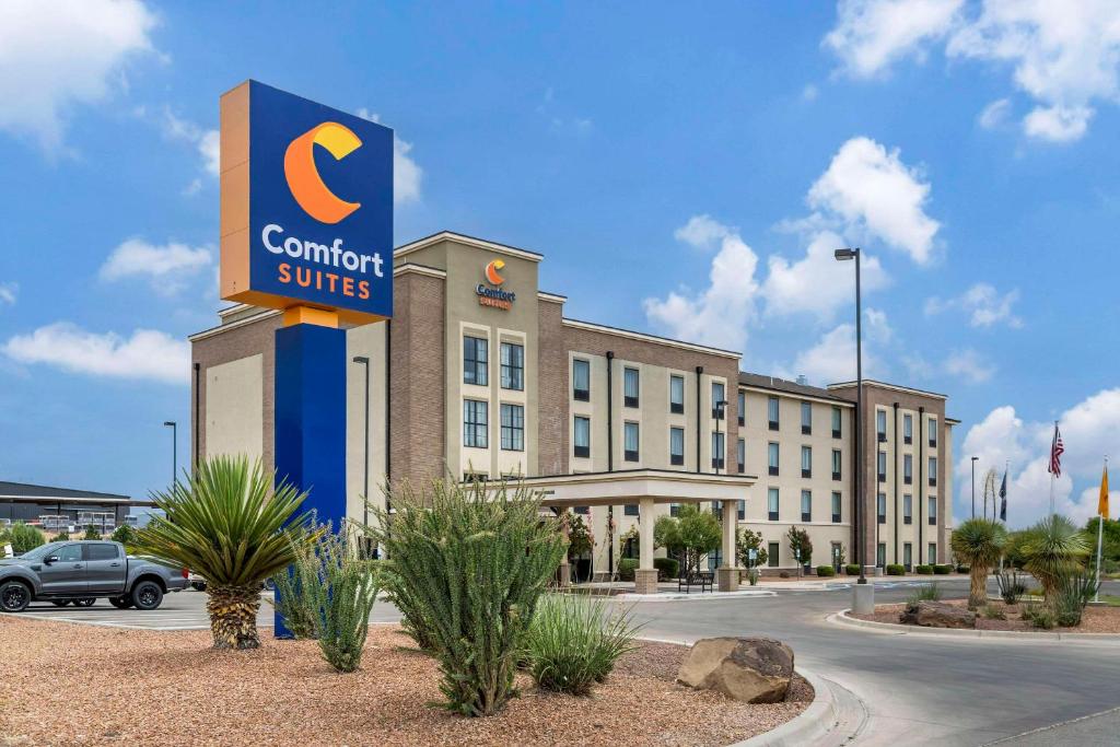 Un panneau indiquant les suites confort se trouve devant le bâtiment. dans l'établissement Comfort Suites Carlsbad, à Carlsbad