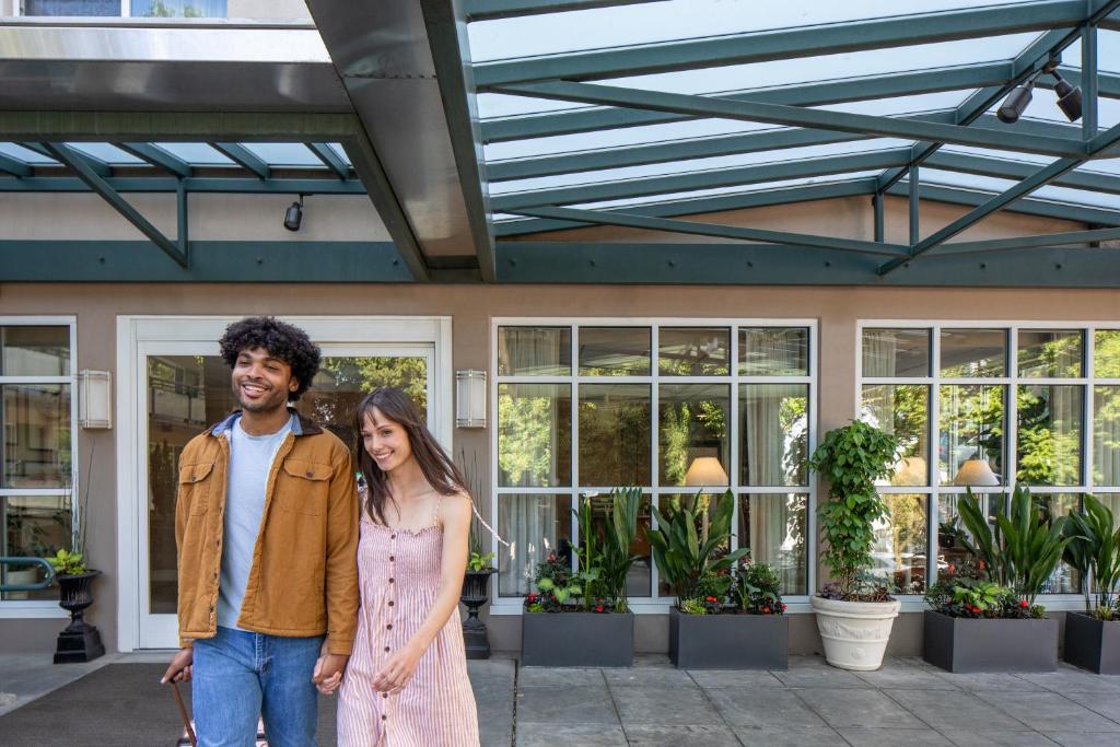 een man en een vrouw die voor een gebouw staan bij Park Lane Suites & Inn in Portland