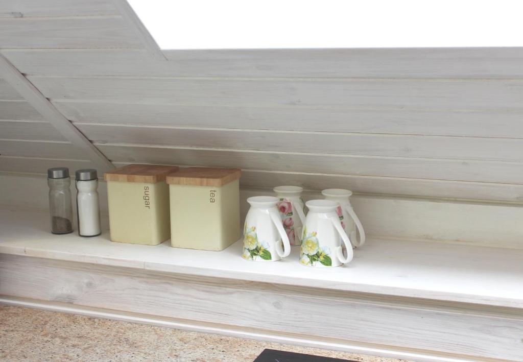 a shelf with four vases and boxes on it at Apartamenti Starp Krastiem 2 in Liepāja