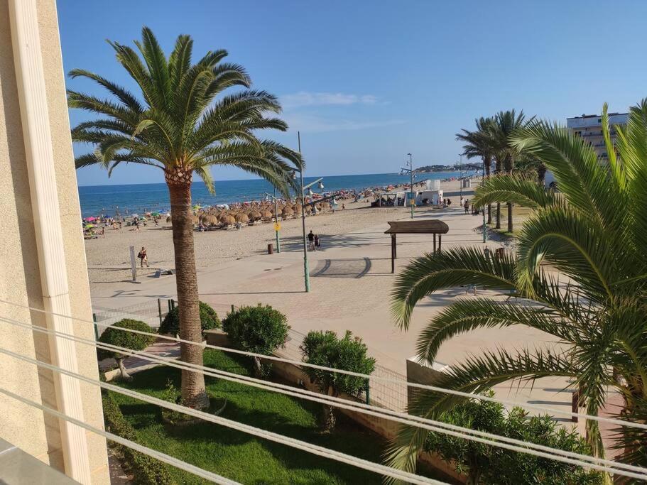 a view of a beach with palm trees and people at A pie de PLAYA in La Pineda