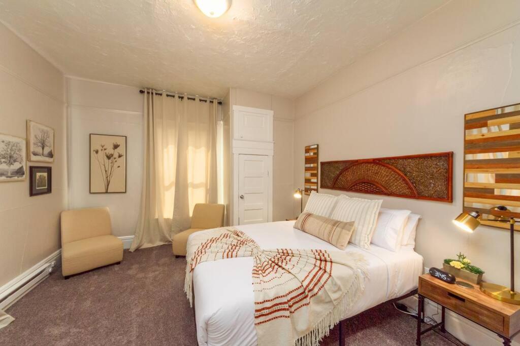 - une chambre avec un grand lit blanc et un bureau dans l'établissement Renovated 2 bed 2 bath Near Arena and Downtown, à Spokane