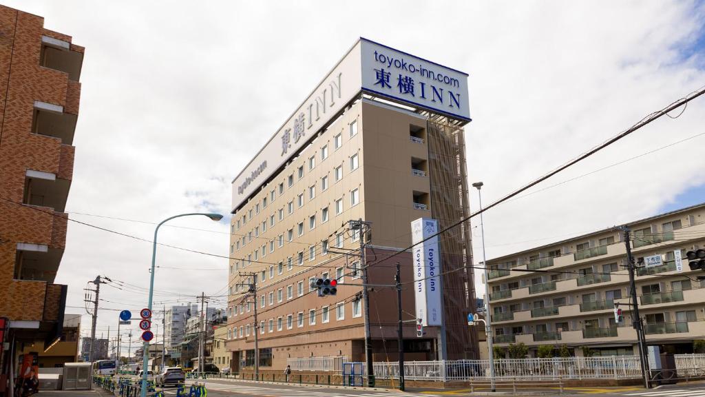 un edificio con un cartel en la parte superior en Toyoko Inn Chofu Keio sen Fuda eki, en Chofu