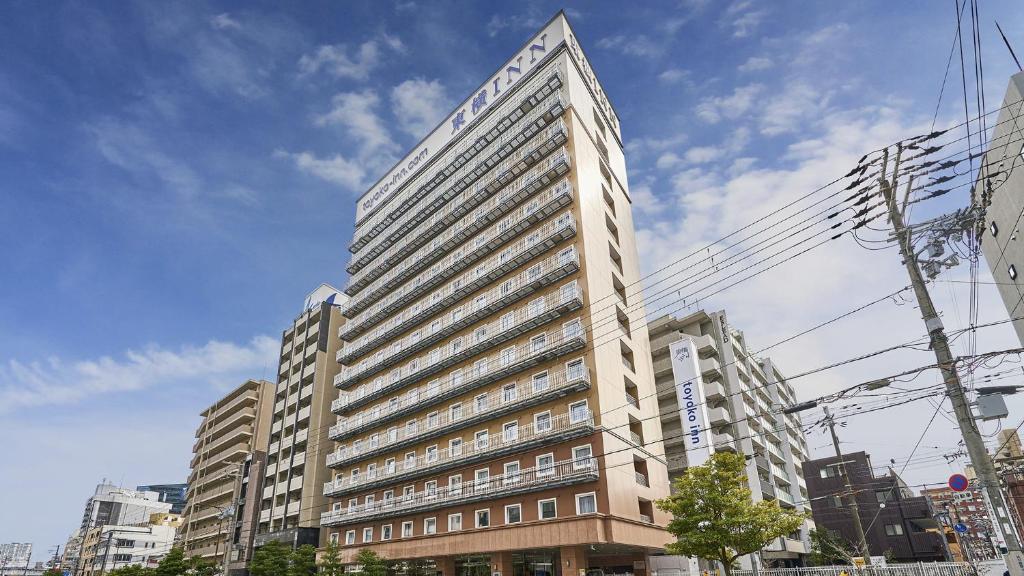 un edificio alto con un cartel en el costado en Toyoko Inn Osaka Tenjinbashi-suji Rokuchome, en Osaka