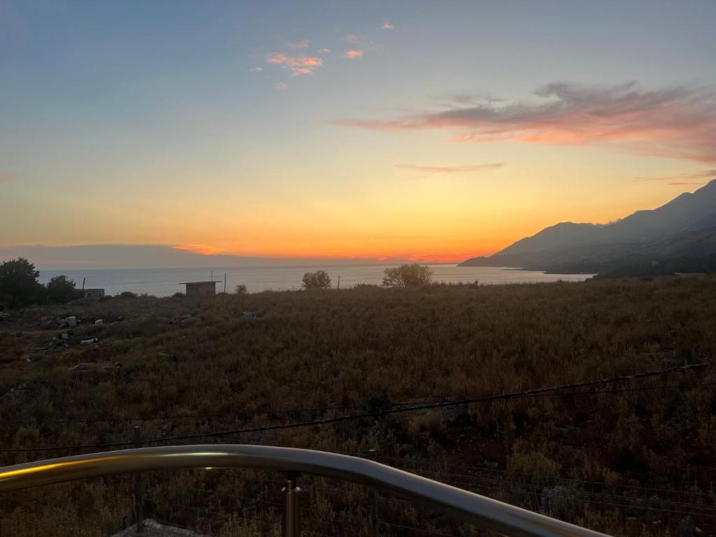 einen Sonnenuntergang über einem Feld mit Meerblick in der Unterkunft Noah's Home in Himarë