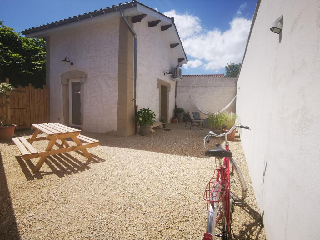 una bicicletta parcheggiata accanto a un edificio con tavolo da picnic di Le Petit Saugnieu a Colombier-Saugnieu