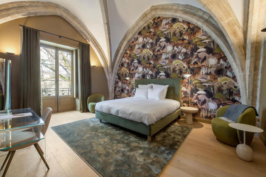 una camera d'albergo con letto e murale di animali di Les Suites de l'Ile Barbe a Lione