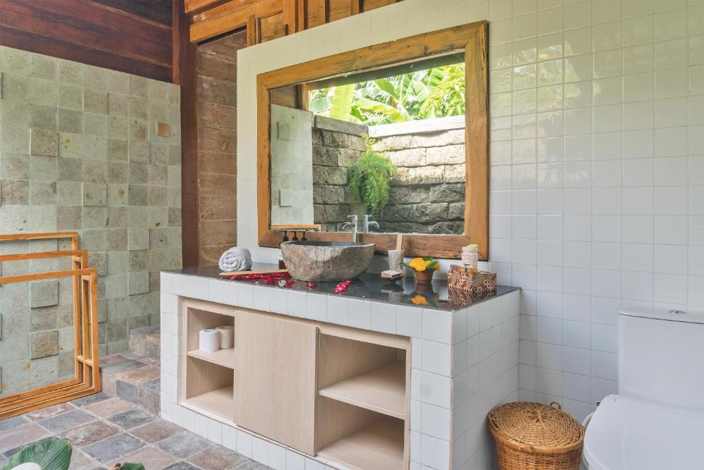 y baño con lavabo y espejo. en Nunu Bali Eco Friendly Retreat, en Canggu