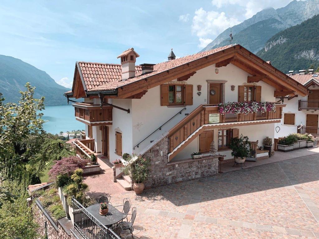 een groot huis met een balkon en een meer bij Villa la Dama del Lago in Molveno