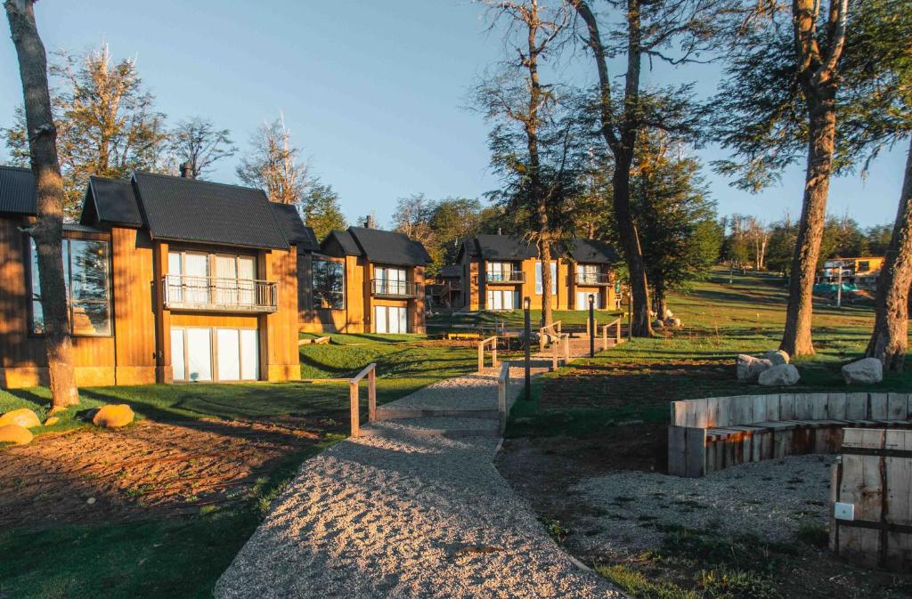 a row of houses in a park with trees at El Refugio Ski & Summer Lodge in San Martín de los Andes