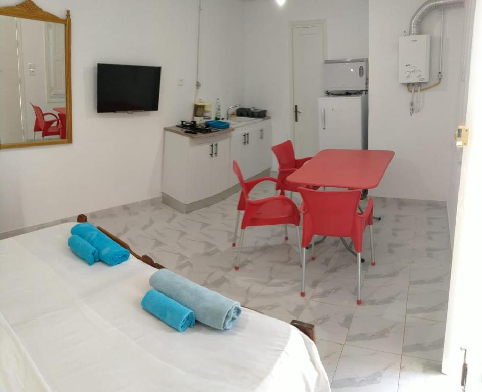 Cette chambre comprend un lit, une table et des chaises rouges. dans l'établissement Dar Lilia Monastir, à Monastir