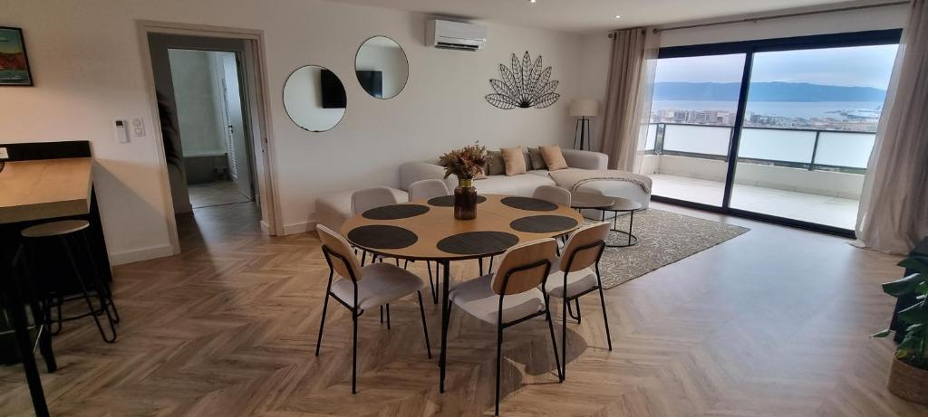 een woonkamer met een tafel en stoelen en een bank bij Palazzu B reservation 3 nuits minimum in Ajaccio