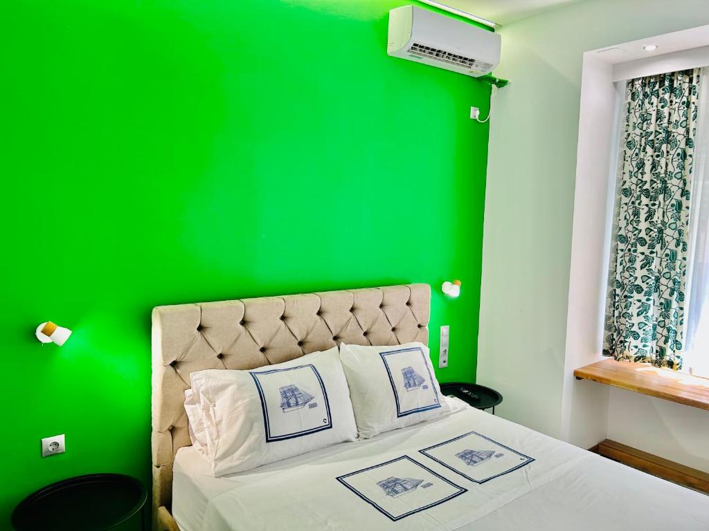 een groene slaapkamer met een bed met een groene muur bij CASA VERDE di Giorgio 10 mins walk from Piraeus port in Piraeus