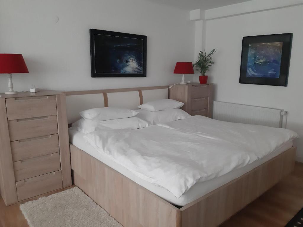 a bedroom with a large bed with white sheets and pillows at Apartment Berglez in Škofja Loka