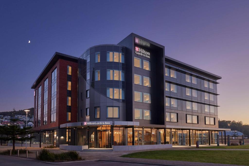 un grand bâtiment en verre avec un bâtiment dans l'établissement Hilton Garden Inn Albany, WA, à Albany