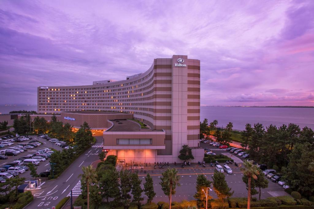 ein Gebäude mit vielen Autos auf einem Parkplatz in der Unterkunft Hilton Tokyo Bay in Urayasu