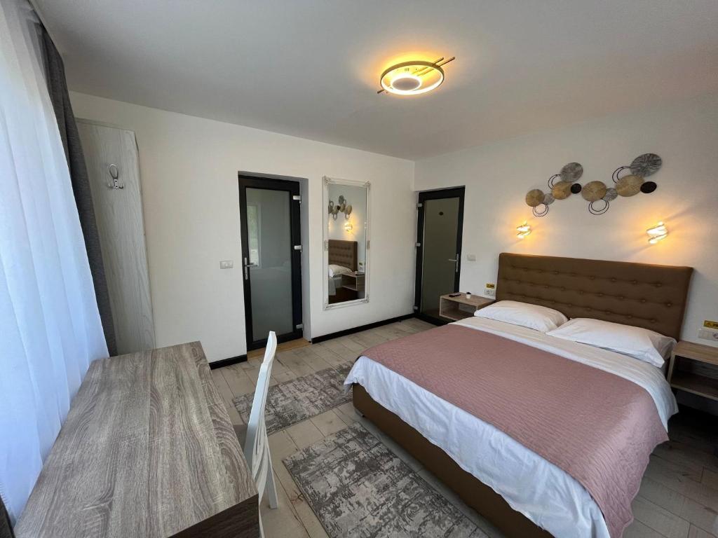 een slaapkamer met een groot bed en een tafel bij Casa Boila in Bîrsana