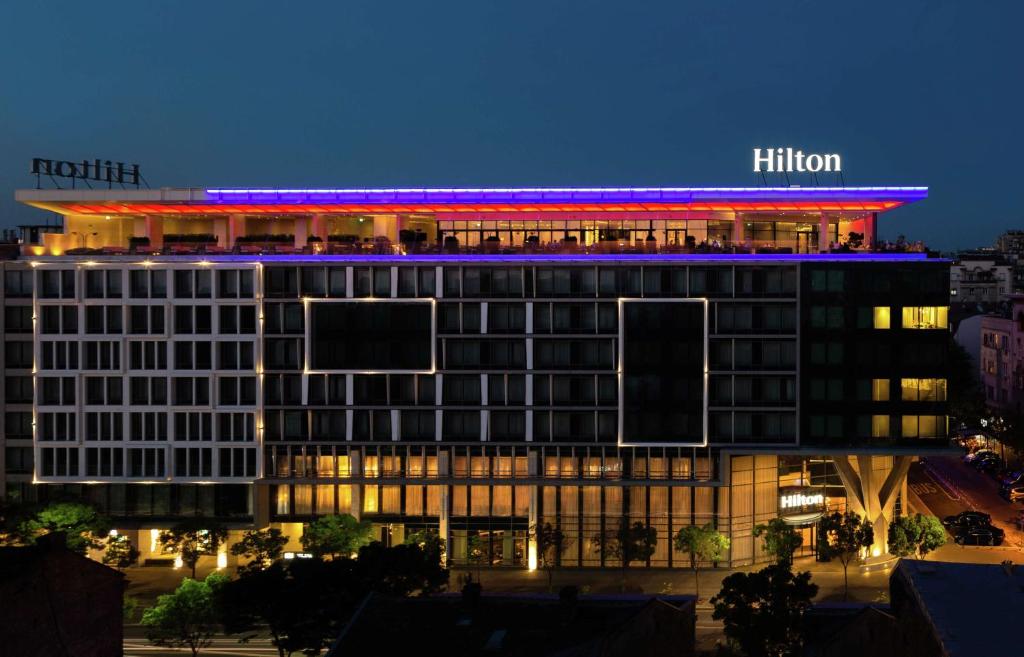 um edifício de hotel com um Hilton à noite em Hilton Belgrade em Belgrado