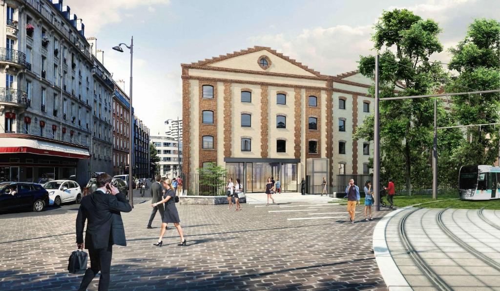 a group of people crossing a street in front of a building at Hilton Garden Inn Paris La Villette in Paris