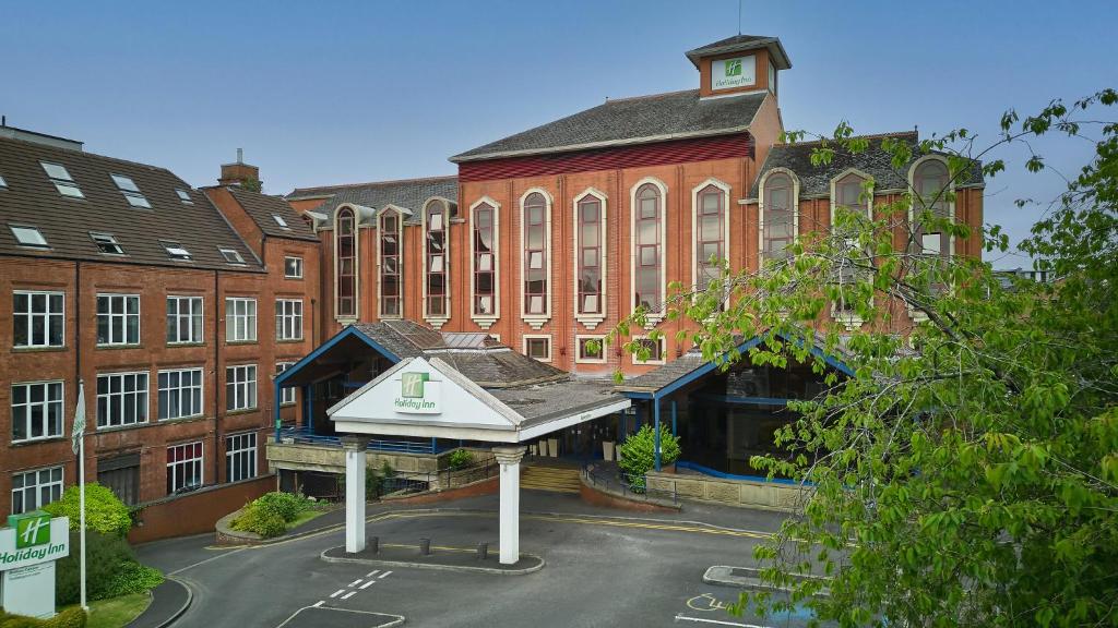 un grande edificio in mattoni con un cartello di fronte di Holiday Inn Bolton Centre, an IHG Hotel a Bolton