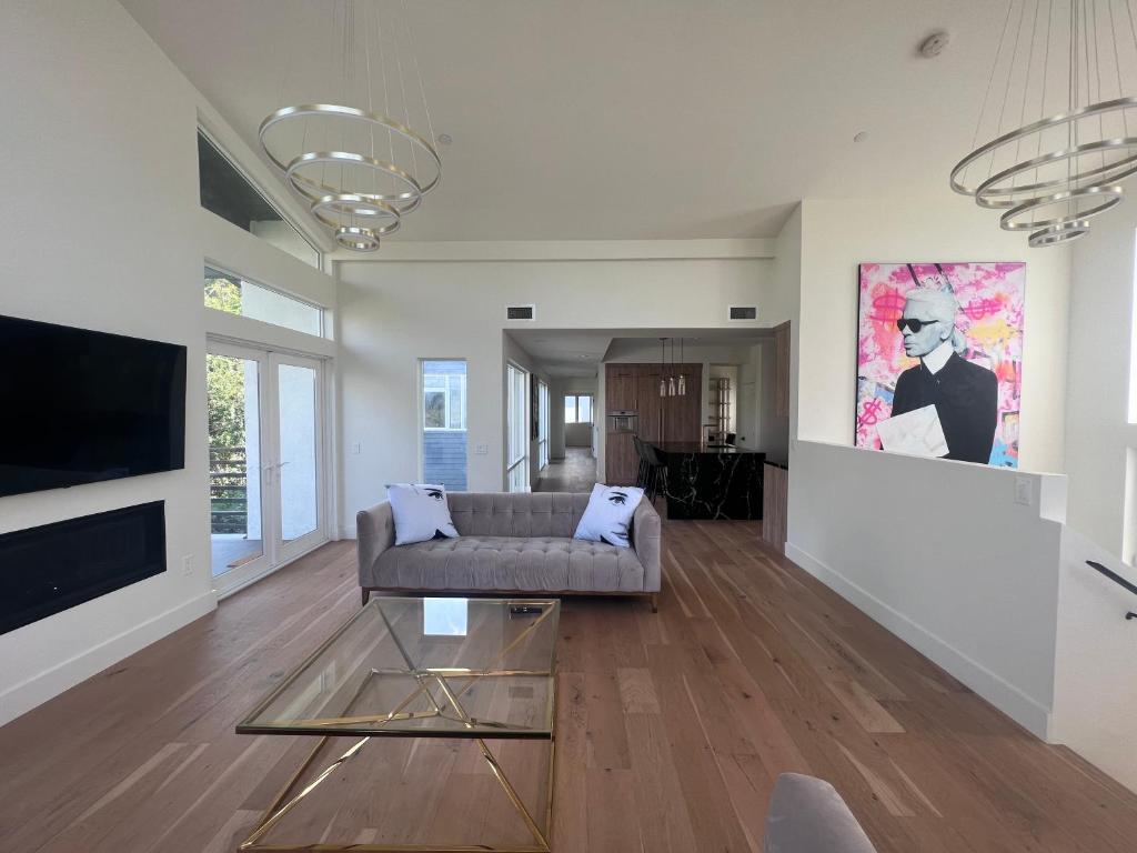 ein Wohnzimmer mit einem Sofa und einem TV in der Unterkunft Gorgeous New Private and Gated Home in Prime Silver Lake in Los Angeles