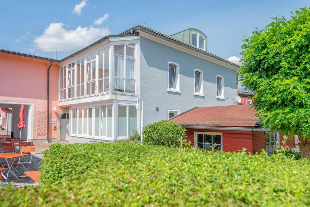 Cette grande maison dispose de fenêtres blanches et d'une cour. dans l'établissement Waidla-Studio, à Freyung