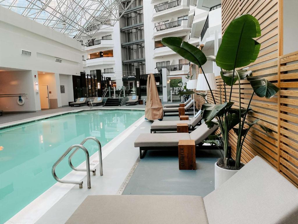 - une piscine avec des chaises longues dans un bâtiment dans l'établissement Hilton Boston-Woburn, à Woburn