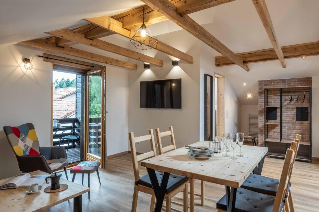 Il comprend une cuisine et une salle à manger avec une table et des chaises en bois. dans l'établissement Ski-Bike-Apartment Bayerwald, à Lohberg