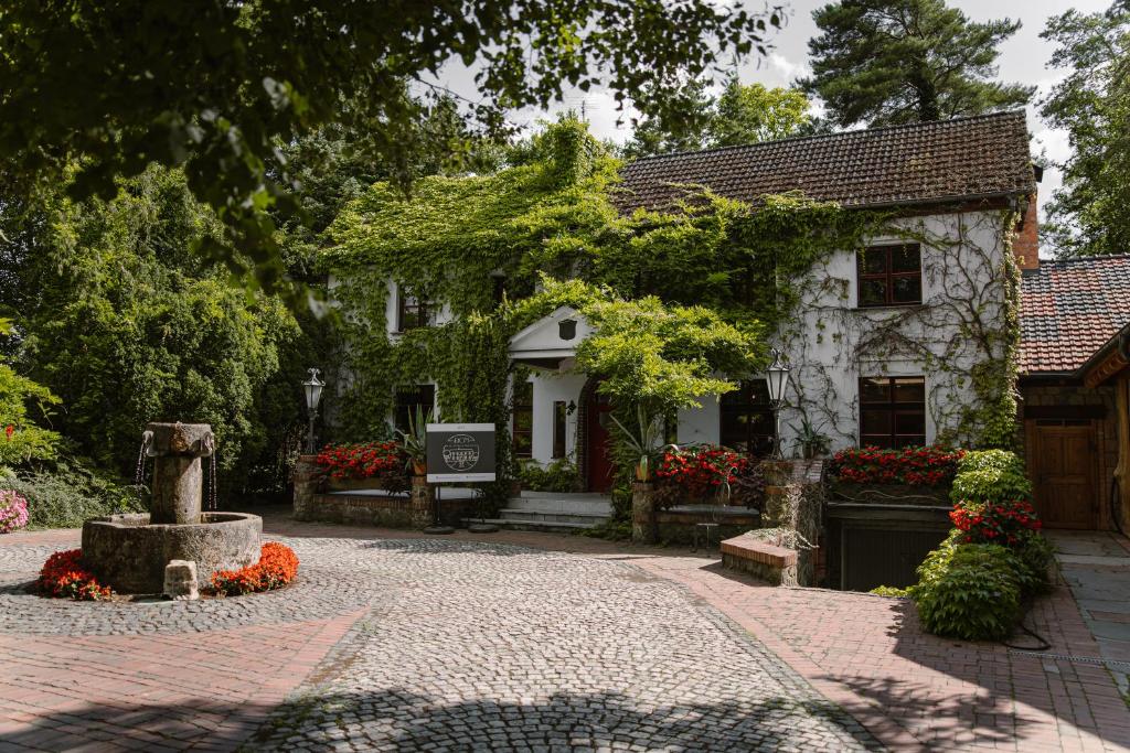 ein kleines Haus mit Blumen davor in der Unterkunft Dom w Starym Parku in Biskupice