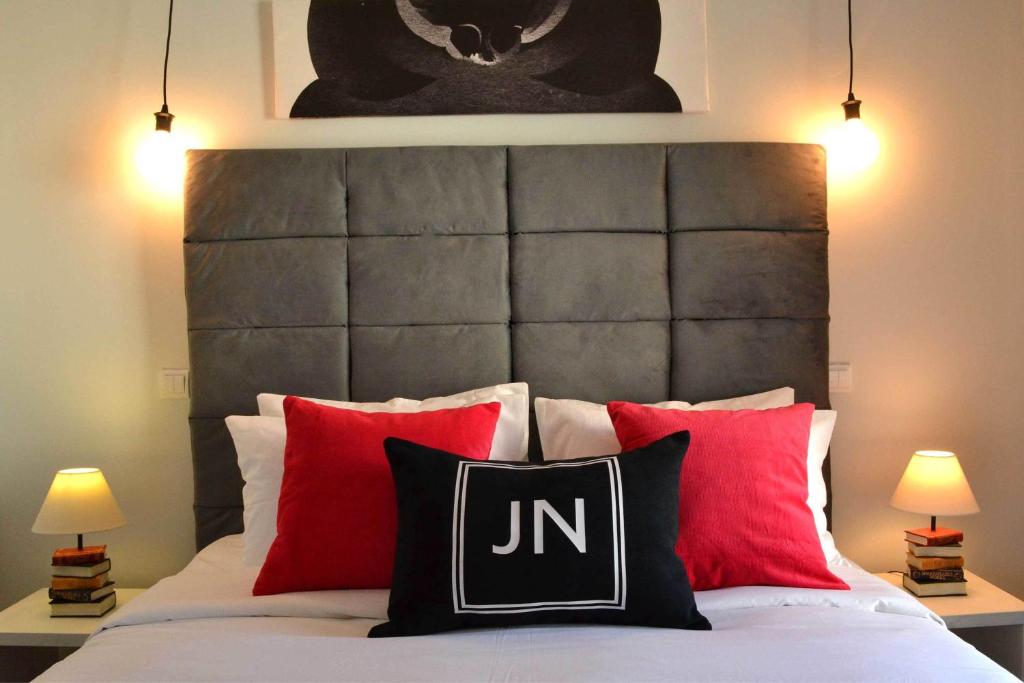 een slaapkamer met een bed met rode en zwarte kussens bij JN Boutique Apartments in Boekarest