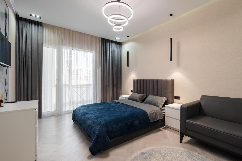 a bedroom with a bed and a couch at Апартаменты бизнес-класса в ЖК 4YOU in Almaty