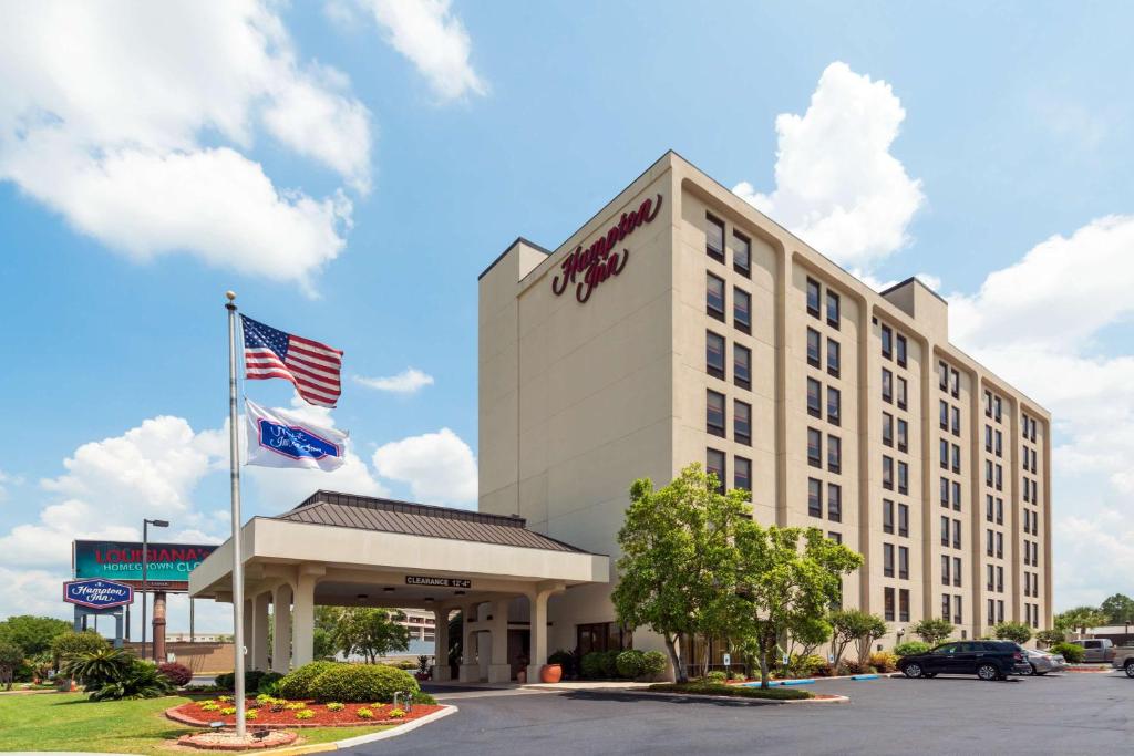 una vista esterna di un hotel con bandiera americana di Hampton Inn I-10 & College Drive a Baton Rouge