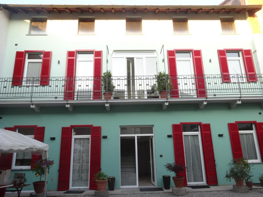 une façade de bâtiment avec volets rouges dans l'établissement Notte di Note - home hospitality, à Busto Arsizio