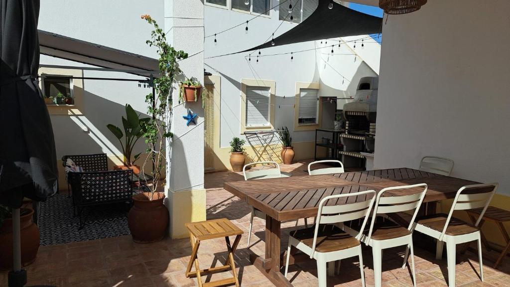 un patio con tavolo e sedie in legno sul balcone. di Casa da Praia - Manta Rota a Manta Rota