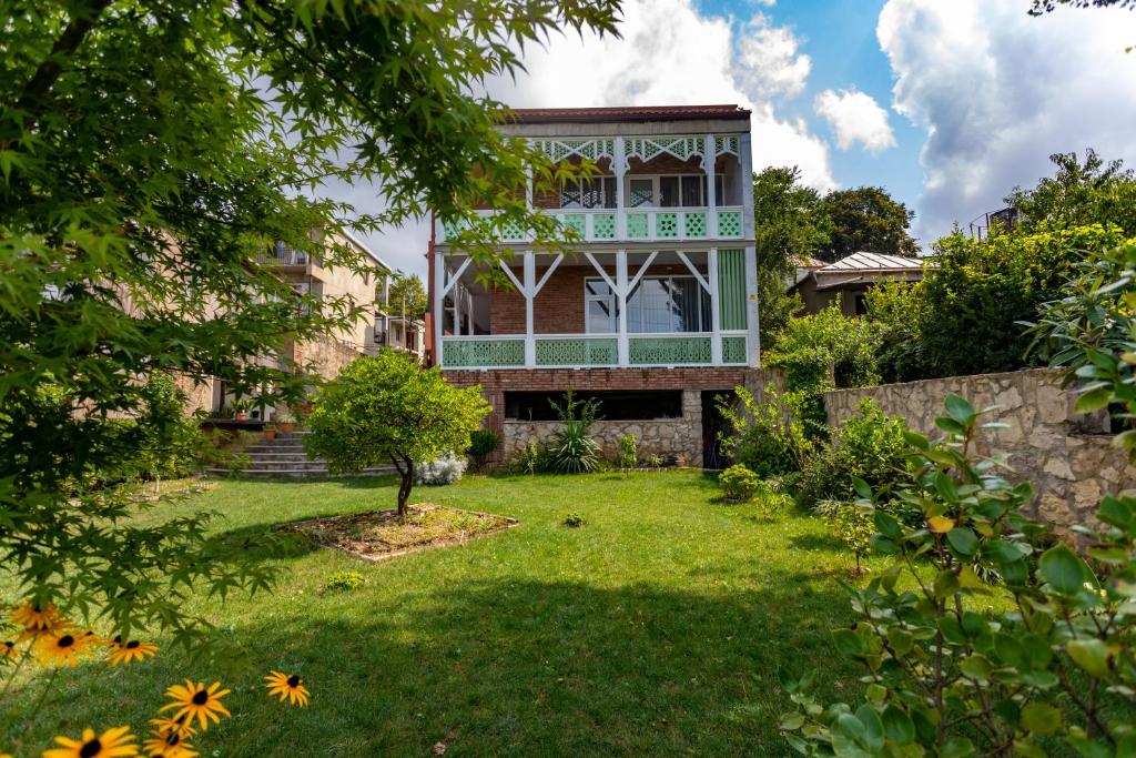 a house with a garden in front of it at Hotel Paradise Road in Kutaisi