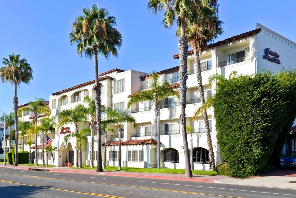 un bâtiment blanc avec des palmiers sur le côté d'une rue dans l'établissement Hampton Inn & Suites San Clemente, à San Clemente