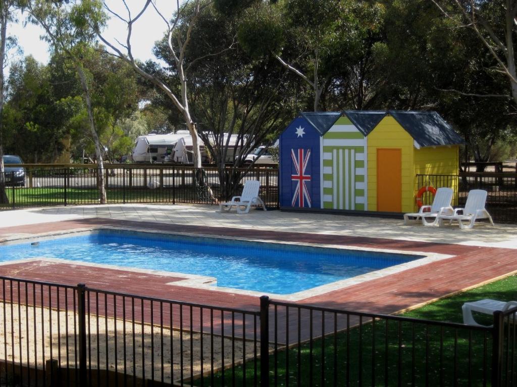 une petite piscine avec un bâtiment à côté d'une clôture dans l'établissement BIG4 Port Willunga Tourist Park, à Aldinga