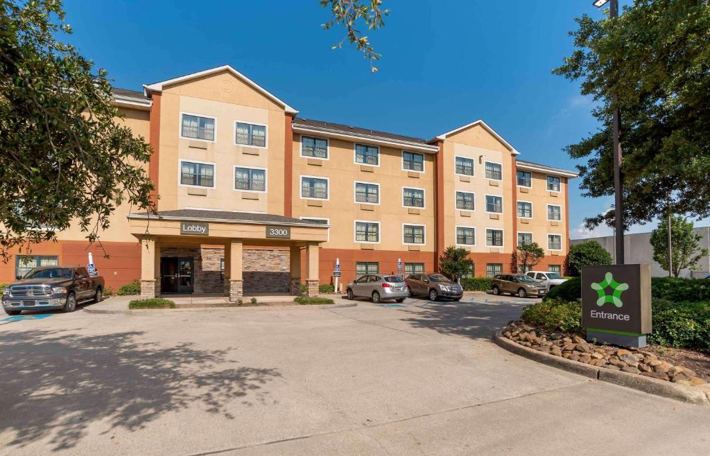 un grande edificio con auto parcheggiate in un parcheggio di Extended Stay America Suites - New Orleans - Metairie a Metairie