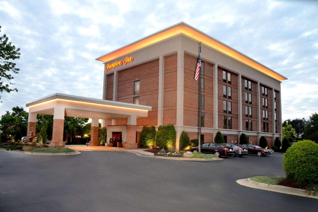 un hotel con una bandiera americana in un parcheggio di Hampton Inn Raleigh Capital Blvd North a Raleigh