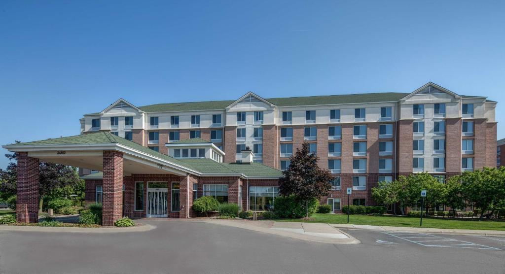 um grande edifício de tijolos com um parque de estacionamento em frente em Hilton Garden Inn Detroit Metro Airport em Romulus