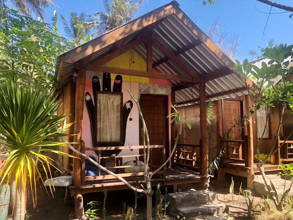 une petite maison avec une terrasse couverte dans un jardin dans l'établissement Easy Bungalow, à Gili Trawangan