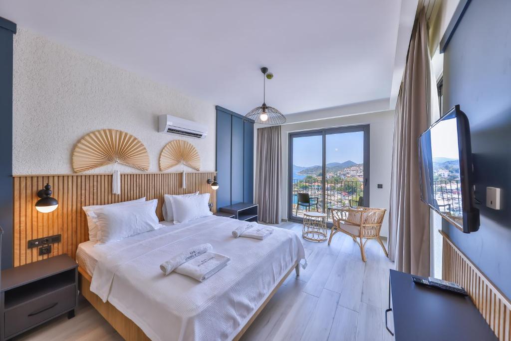 Cette chambre comprend un lit et une grande fenêtre. dans l'établissement Kas Athena Hotel, à Kaş