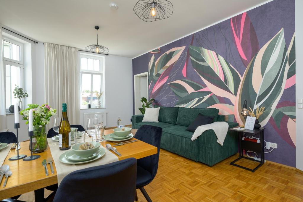 een woonkamer met een groene bank en een tafel bij LE Vacation 3-Room-Apartment 67qm, Küche, Netflix, Free-TV in Schkeuditz