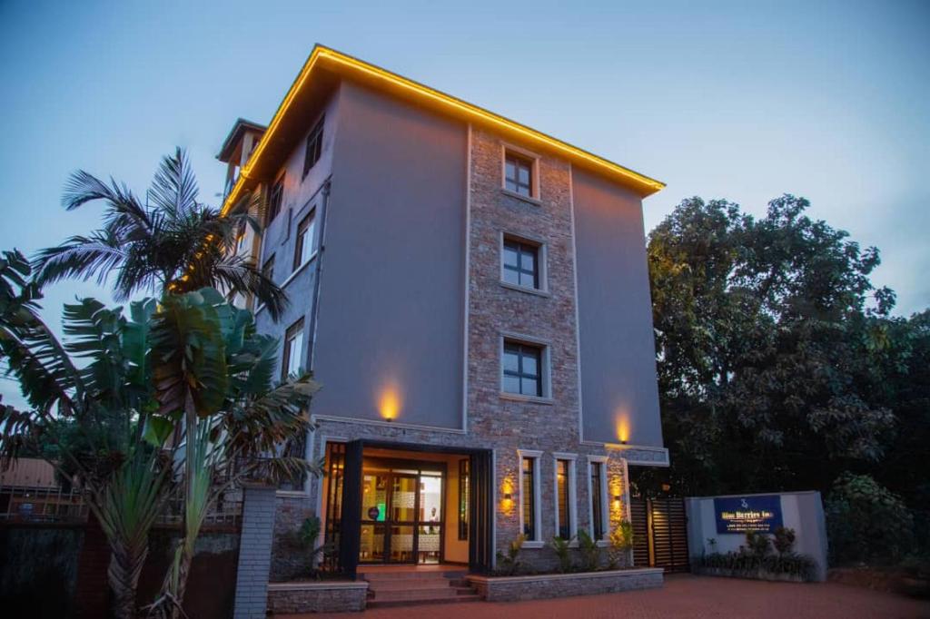 een groot bakstenen gebouw met een voordeur bij Blue Berries Hotel in Entebbe