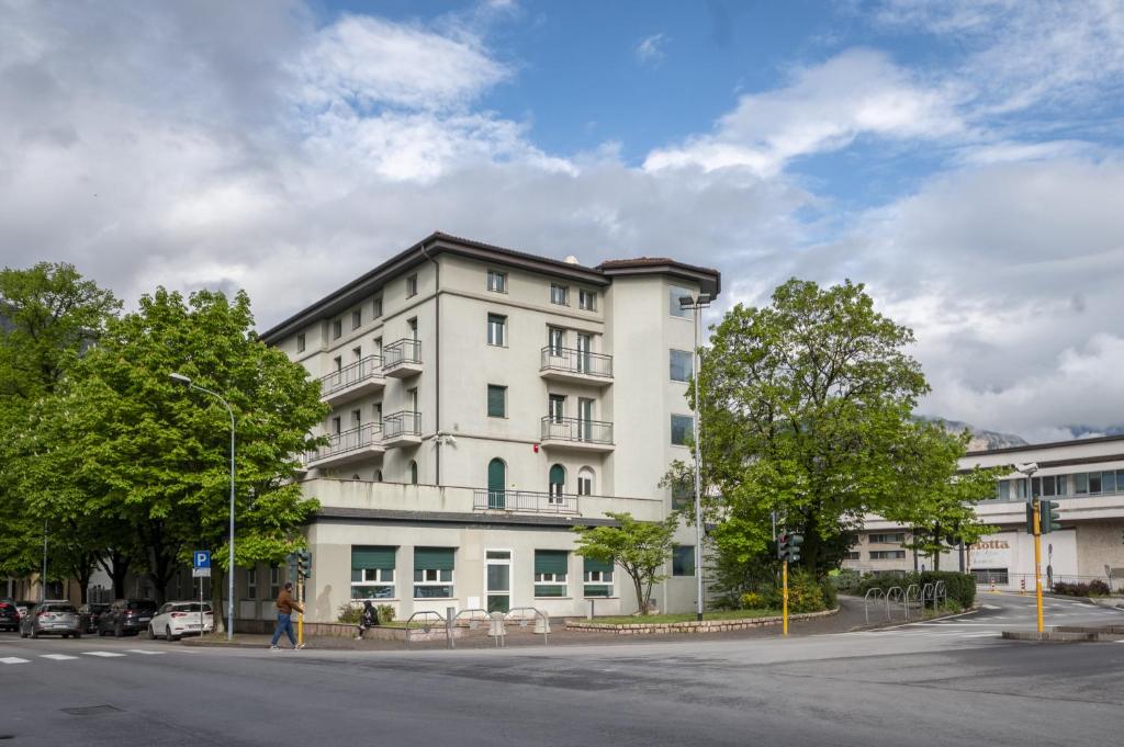 un edificio blanco en la esquina de una calle en Ostello Giovane Europa di Trento, en Trento